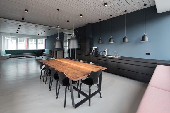 Dunkle, moderne Küche mit großen hellbraunen Esstisch