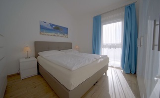 Lichtdurchflutetes Schlafzimmer mit hellem Holzfu&szlig;boden