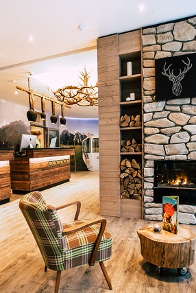 gem&uuml;tliche Hotellounge mit Sitzm&ouml;glichkeit vor einem Kamin