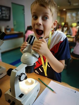 Zdumiony uczestnik kolonii z mikroskopem.