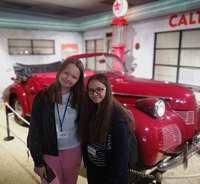 Uczestniczki obozu na tle starego modelu Volvo.