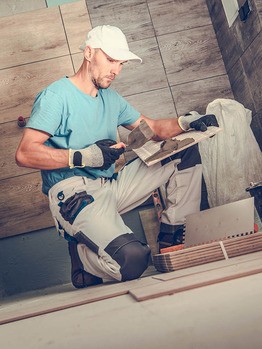 Handwerker veregt Fliesenboden