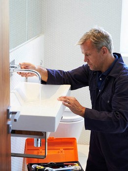 Handwerker montiert weißes keramik Waschbecken