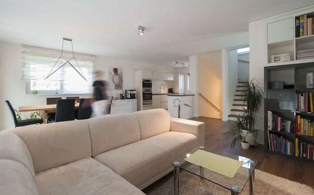 Helles und gem&uuml;tliches Wohnzimmer mit dunklem Holzfu&szlig;boden