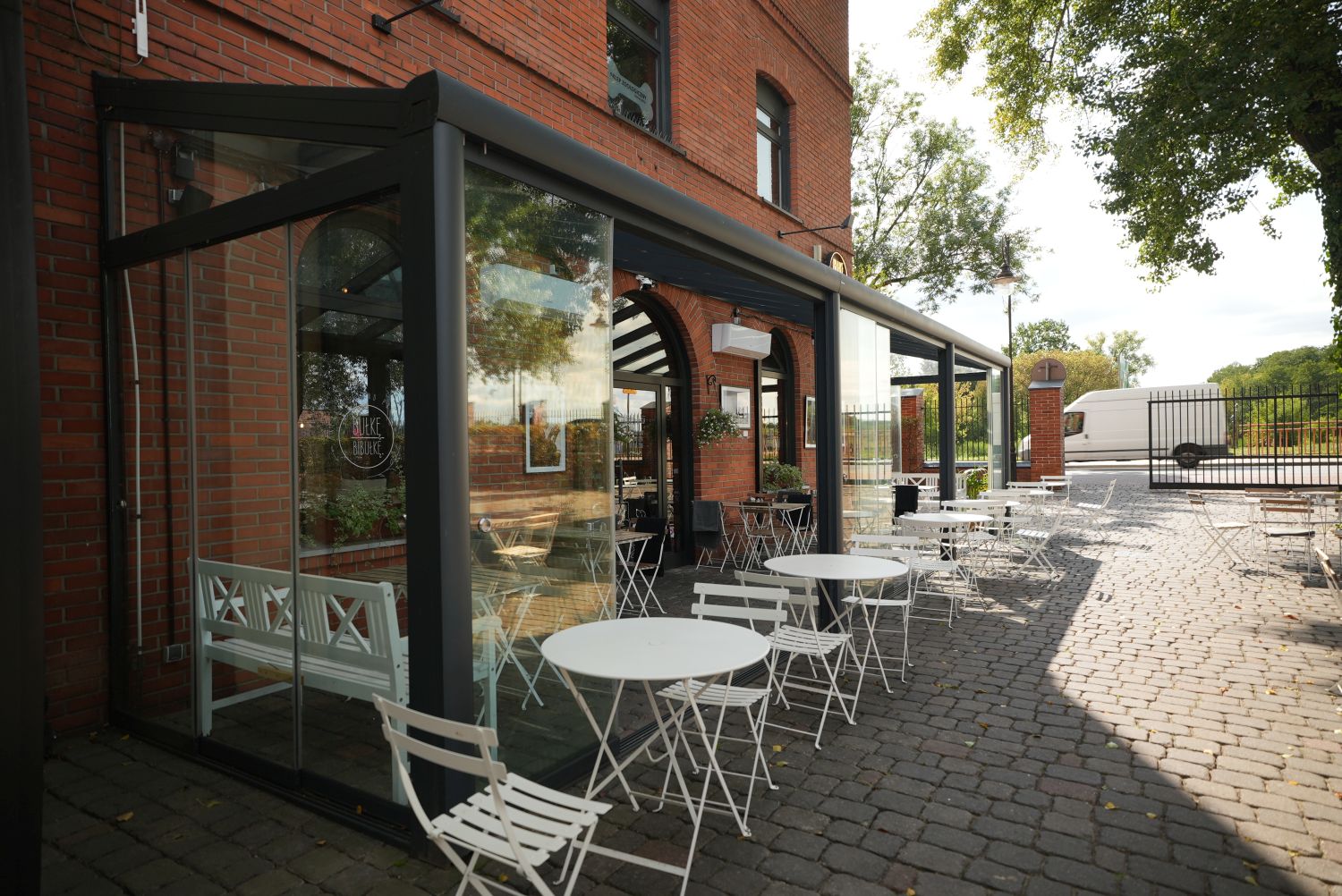 Wnętrze restauracji w ogrodzie zimowym ze stolikami i nowoczesnymi meblami