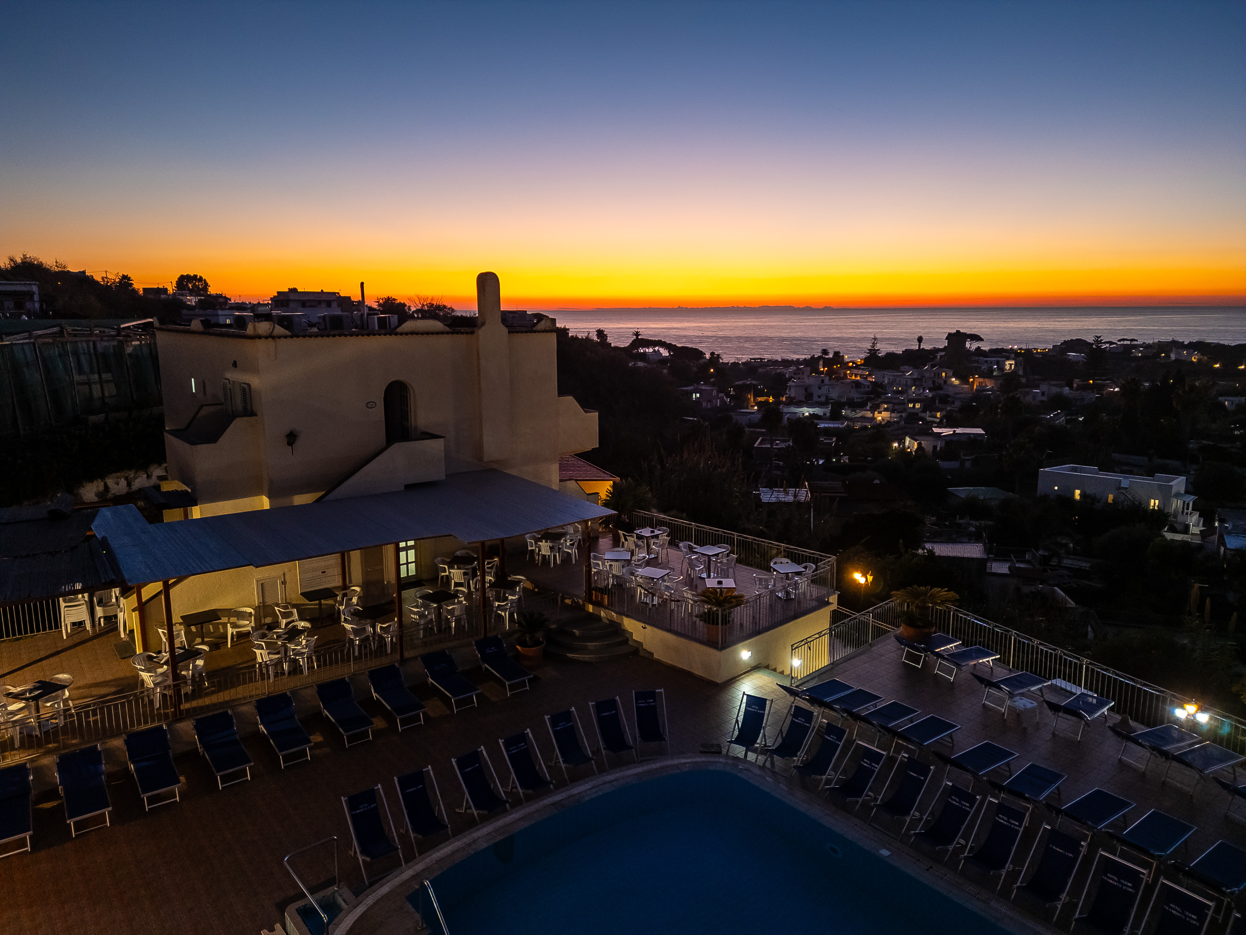 Borgo costiero italiano sulla scogliera al tramonto con vista panoramica sul mare, tipico di Forio d'Ischia