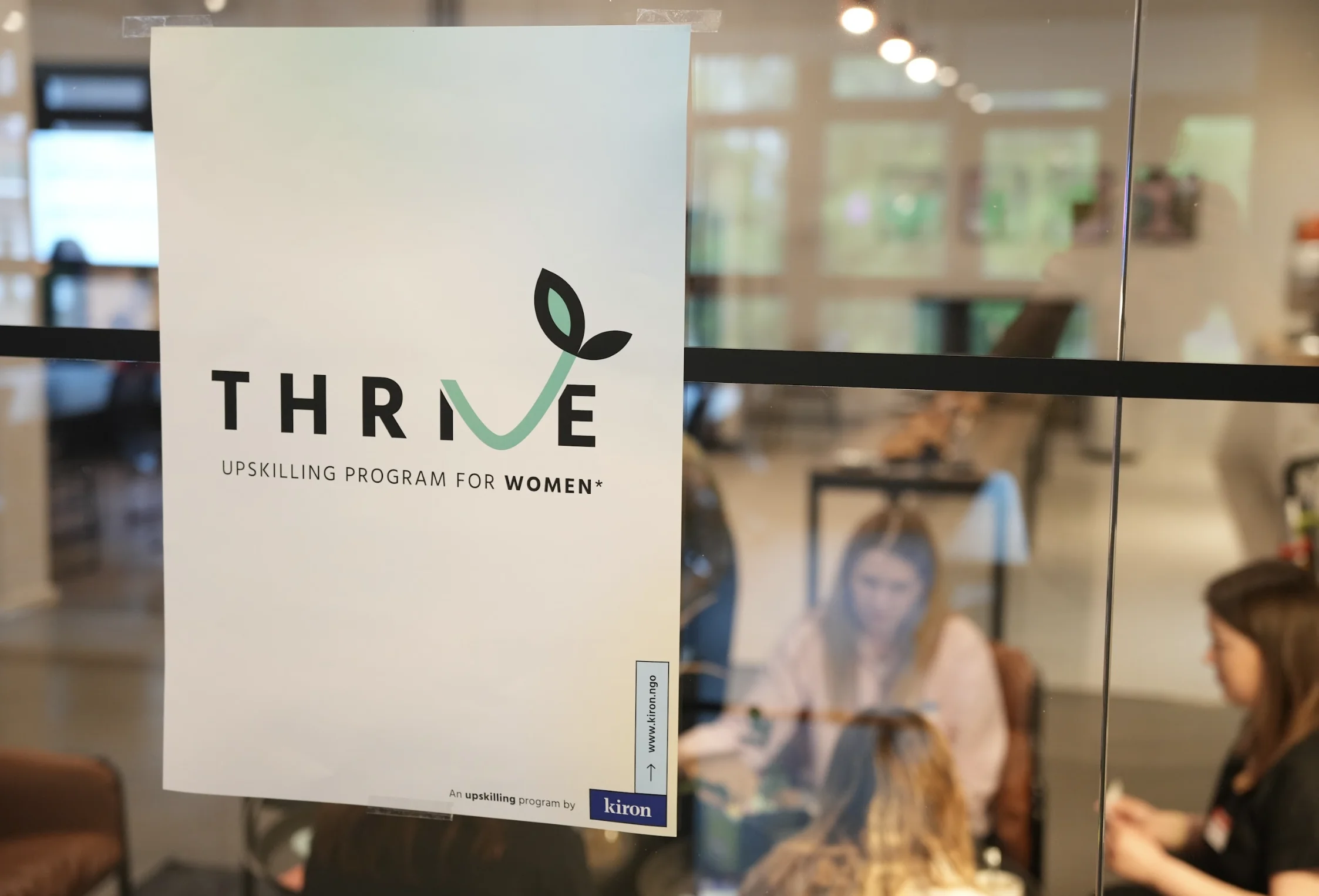 A poster presenting thrive sticking on a glass wall