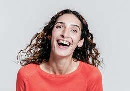 A young women with curly hair smiling