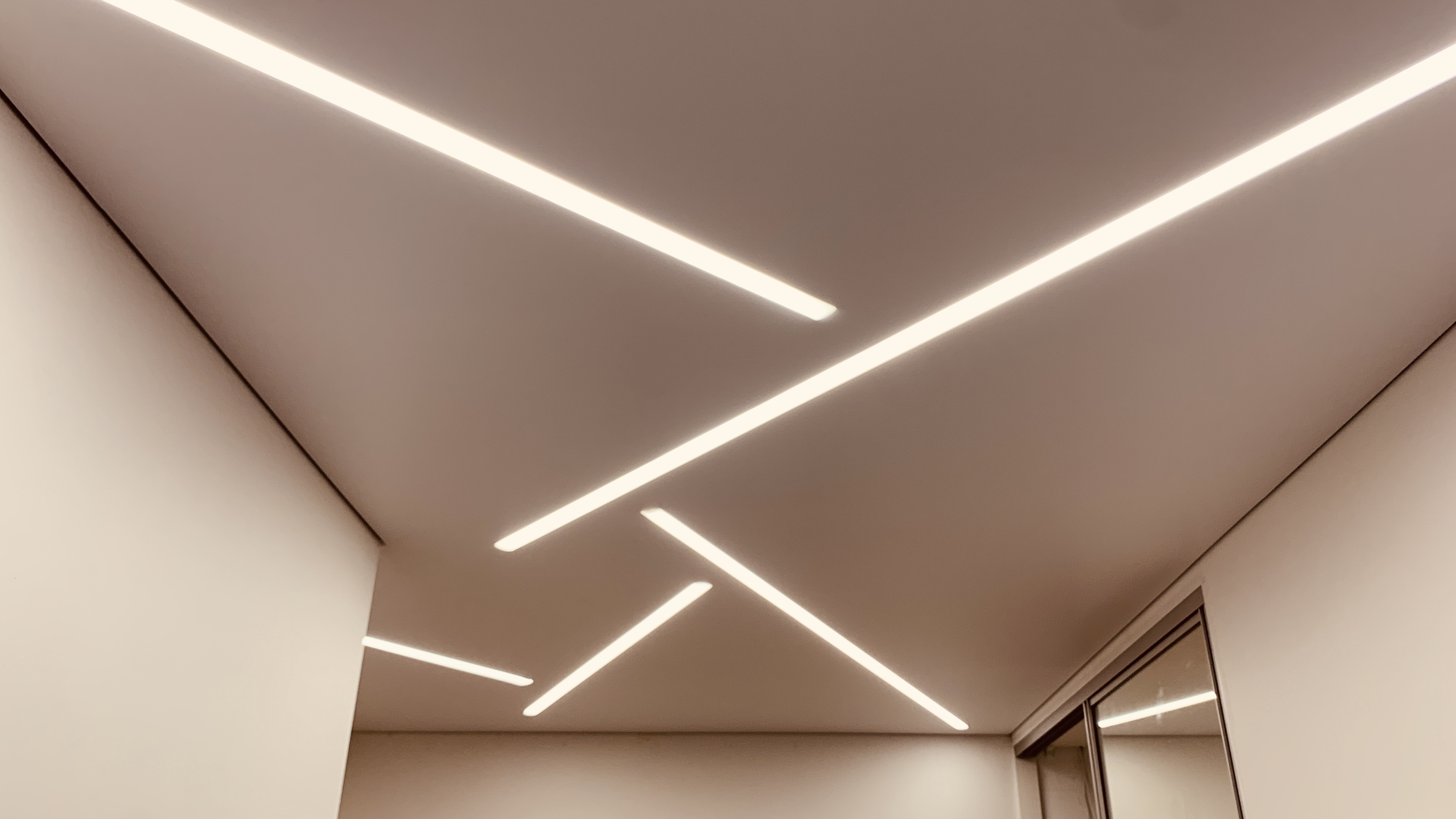 Dekoracyjny sufit napinany z wbudowanymi lampami LED, tworzący wyjątkowy klimat w sypialni.