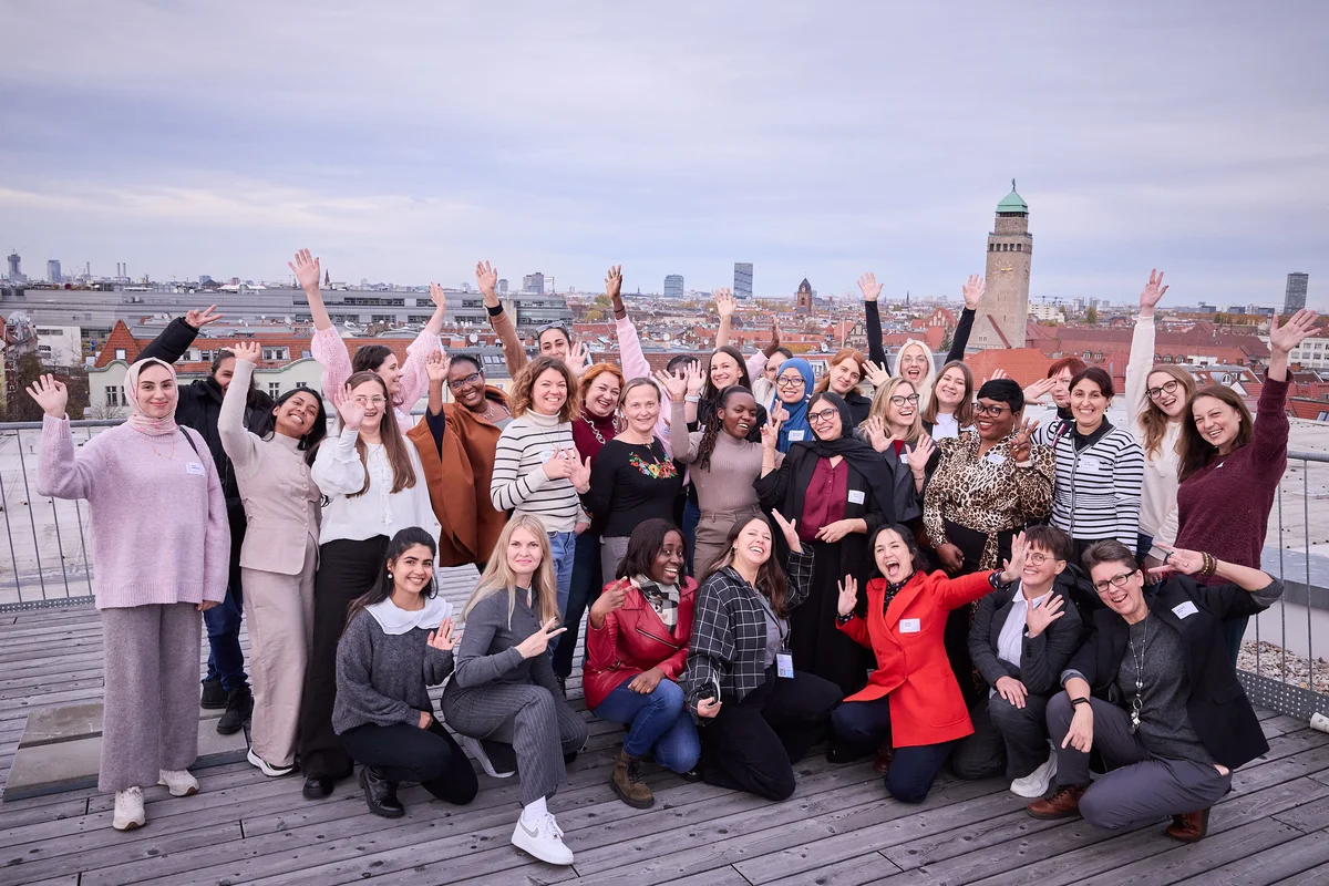 Dina holding up a sign that says "Coding like a girl: Leading innovation"