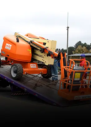 plataforma elevatoria sendo carregada em caminhao prancha
