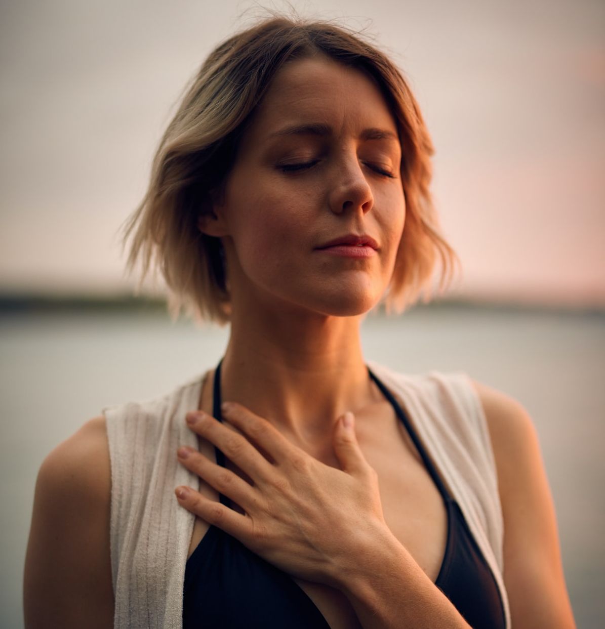 woman with her hand to her heart looking content