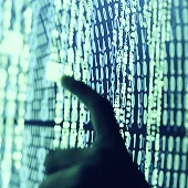 A finger tipping on a big screen with lots of numbers