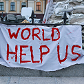 An image of people holding the sign 'Aid doesnt work'