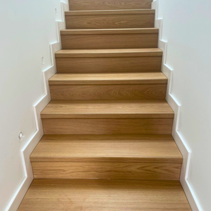 Nowoczesna aranżacja schodów z użyciem paneli winylowych | Salony Fachowiec Panelowe schody w jasnym drewnie – nowoczesne wnętrze z panelami winylowymi, montaż w Salonach Fachowiec