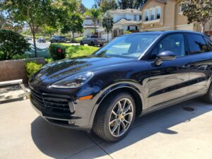 Professional detailer pressure washing a car exterior in Oceanside