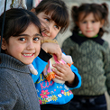 A photo of refugee kids smiling at the camera
