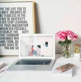 desk with laptop and pink flowers