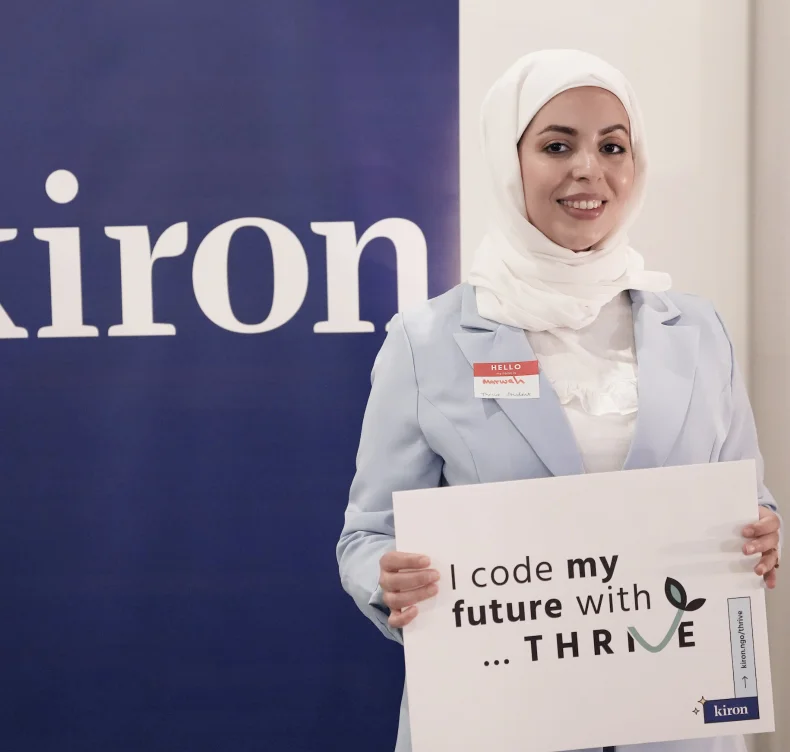 Thrive student holding up a sign saying "I code my future with THRIVE"