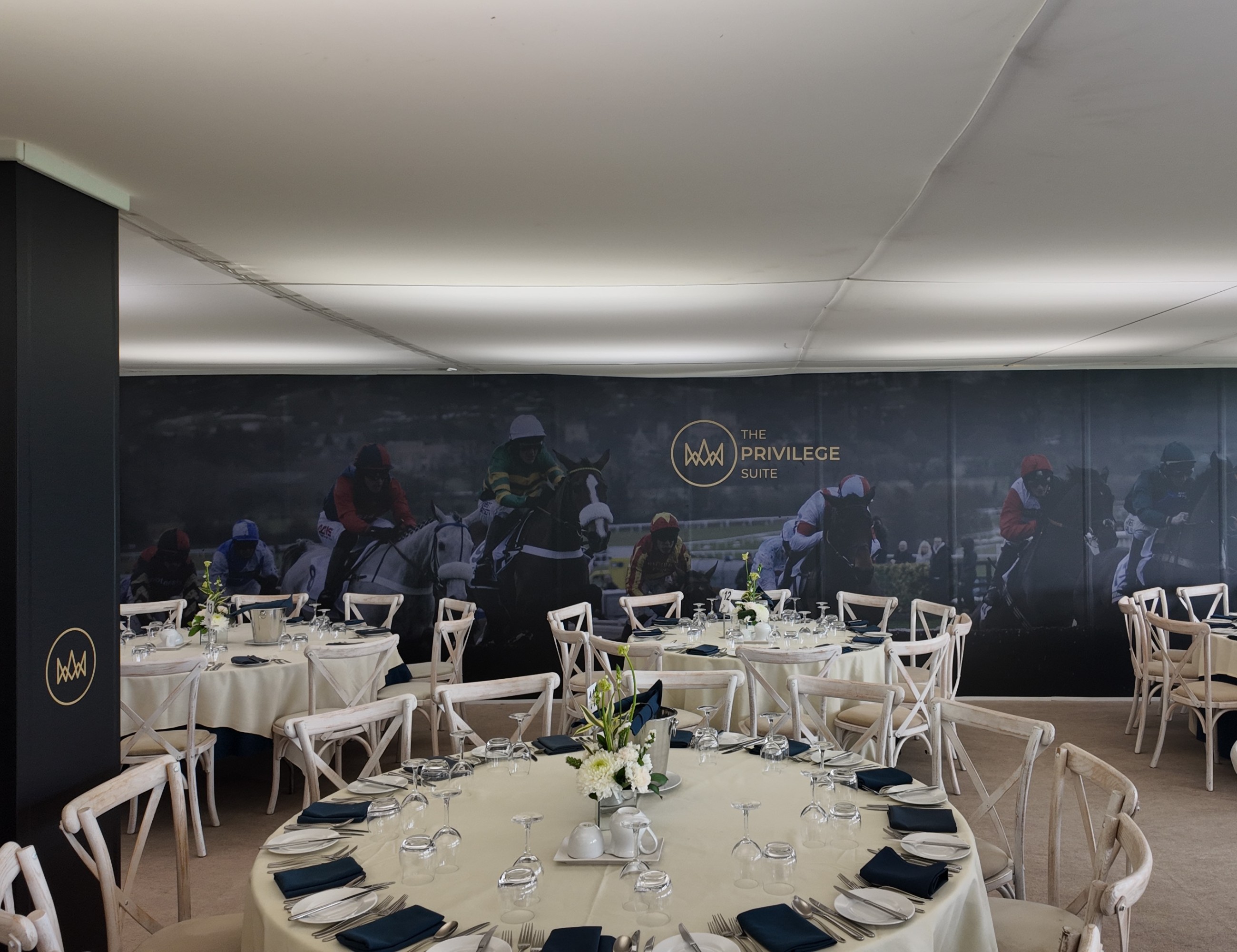 Table settings inside the Privilege Suite at Cheltenham Racecourse, with a racing mural behind