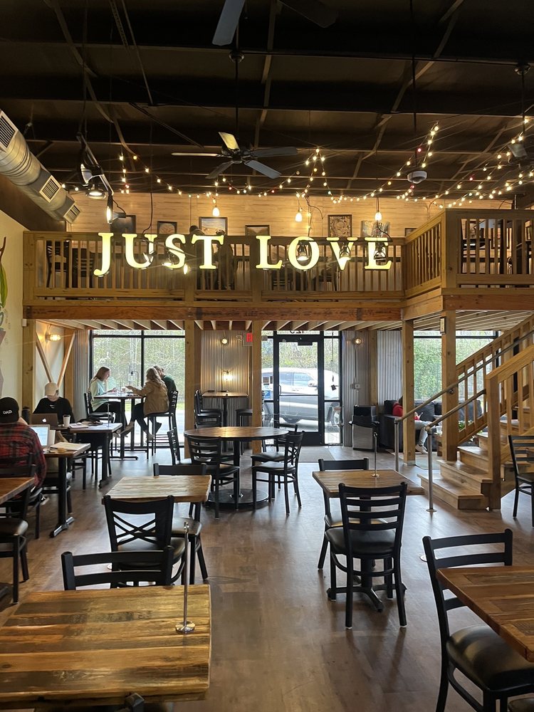 Just Love Coffee Cafe interior with menu area, seating, and cafe branding