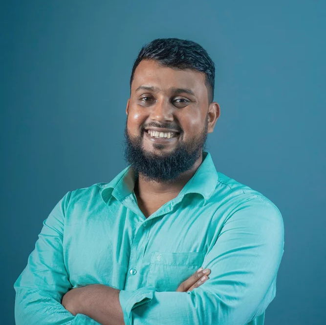 Male, bearded PoC smiling into the camera
