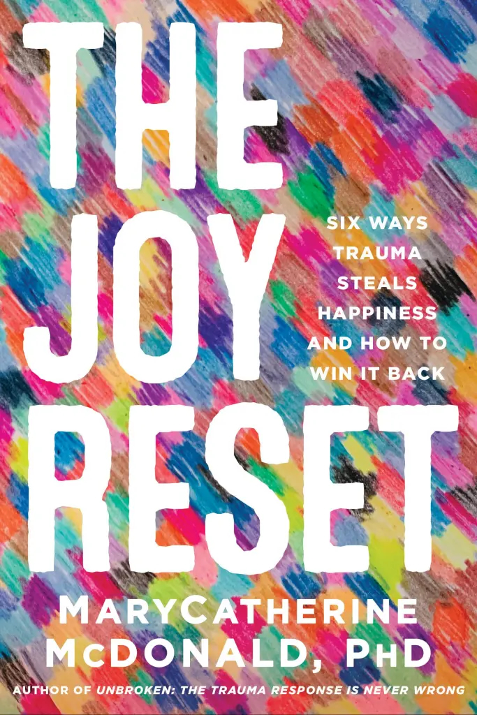 Cover of the book “The Joy Reset” by Dr. MaryCatherine McDonald, featuring the subtitle “Six ways trauma steals happiness and how to win it back.” The design includes bold white lettering over a vibrant, multicolored background. A mental health and trauma recovery book focused on reclaiming joy.
