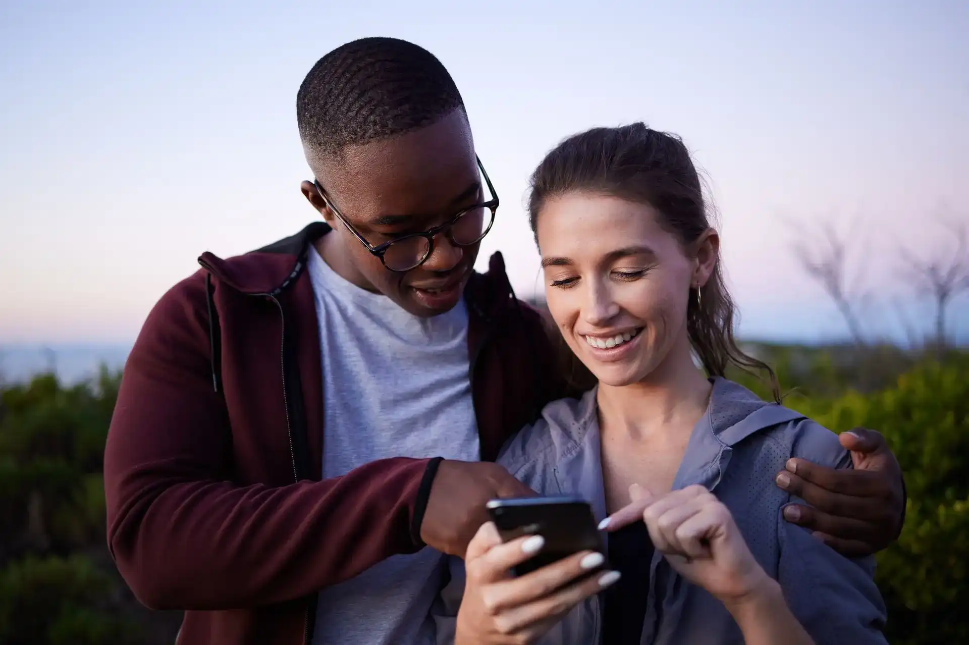 Couple smiling looking at an app on a phone.