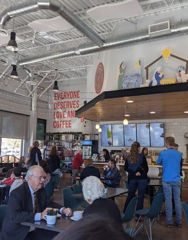 Just Love Coffee Cafe interior with menu area, seating, and cafe branding