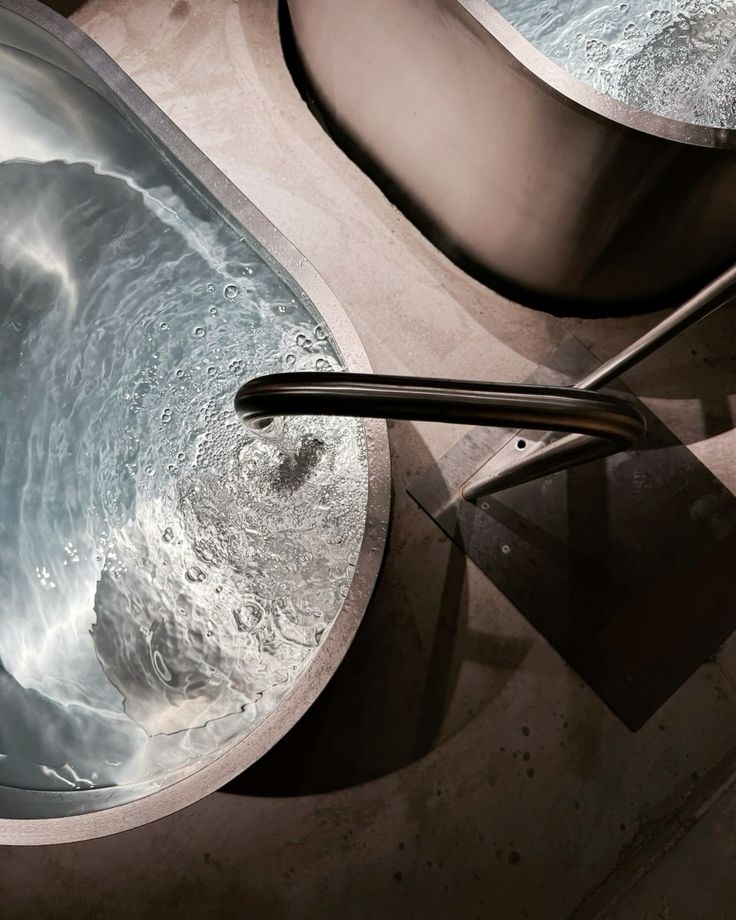 Person submerged in an icy cold plunge bath with dramatic natural lighting