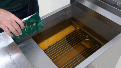 Adding powder to hot oil in filter machine