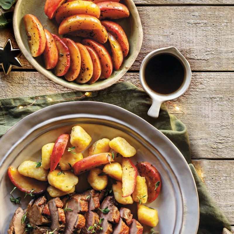 Talerz wypełniony mięsem z kaczki i jabłkami